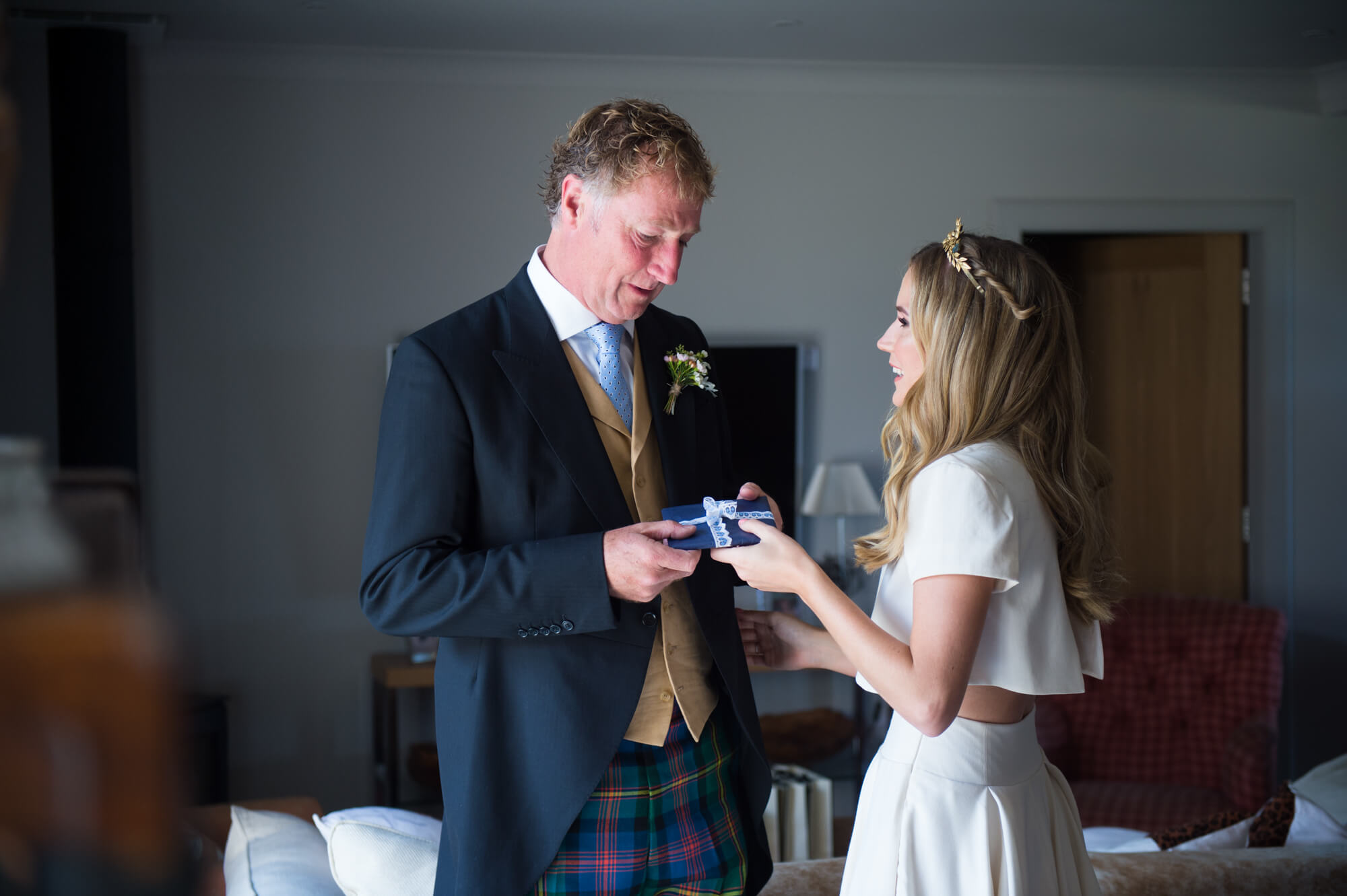 bride giving father of the bride a gift before they leave for church